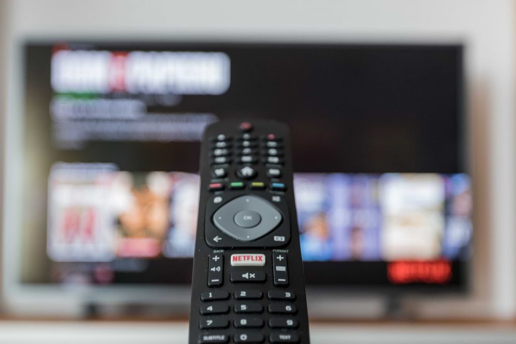 A remote control pointed at a television, searching through the content stored by its HD recorder.