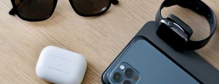An iPhone next to AirPods and an Apple Watch, two of the best mobile phone accessories for iPhone users.