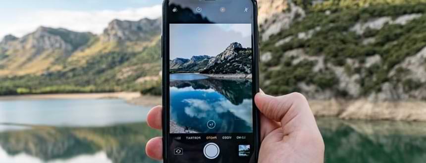 A person takes an image of a mountain with one of the best smartphones for videos and photography