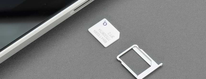 A SIM free smartphone lays next to a SIM card, as if it were just removed from the device.